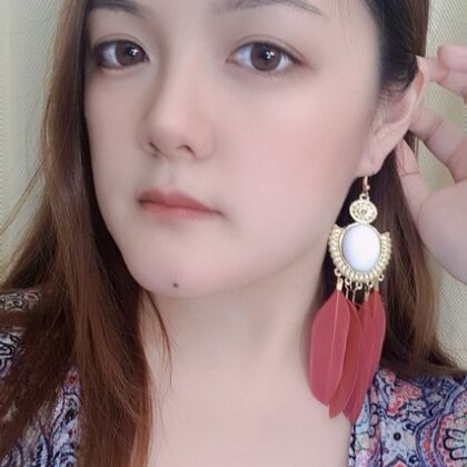 model wearing maroon white faux pearl earrings